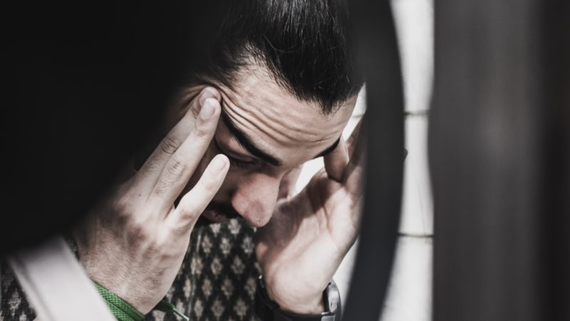 Stressed person holding temples