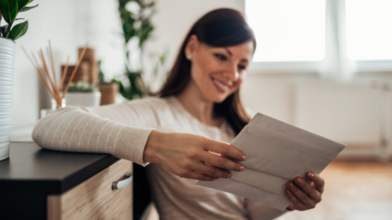 women smiling looking at document in her home