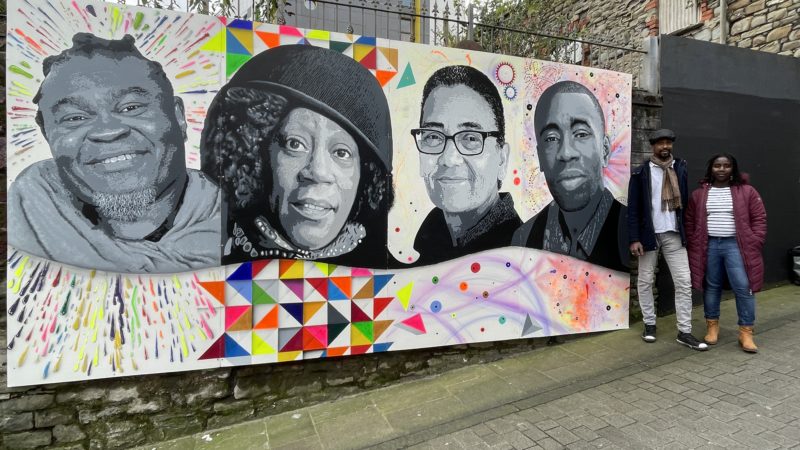 Artists Joel Morris and Melissa Rodrigues stand with their new artwork on King's Lane, Swansea